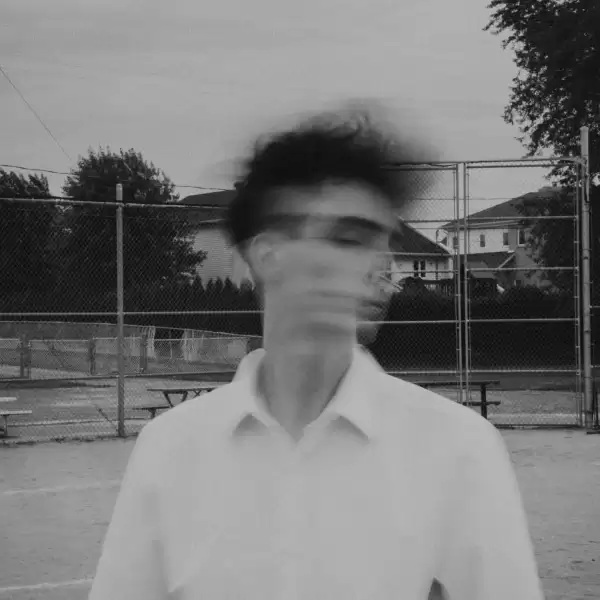 An artistic photo of a young man quickly shaking his head, causing a blurry exposure.